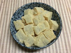 Cover the warabi mochi squares with kinako (roasted soy bean powder)
