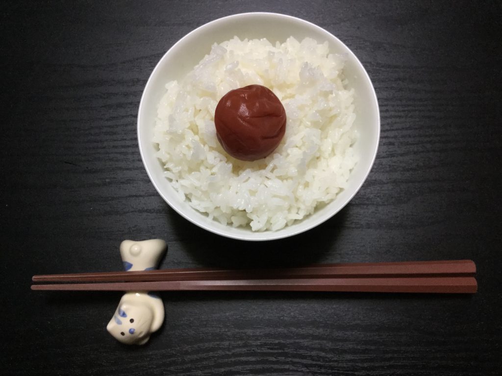 Umeboshi (Japanese pickled plum) on top of a bowl of steaming hot rice