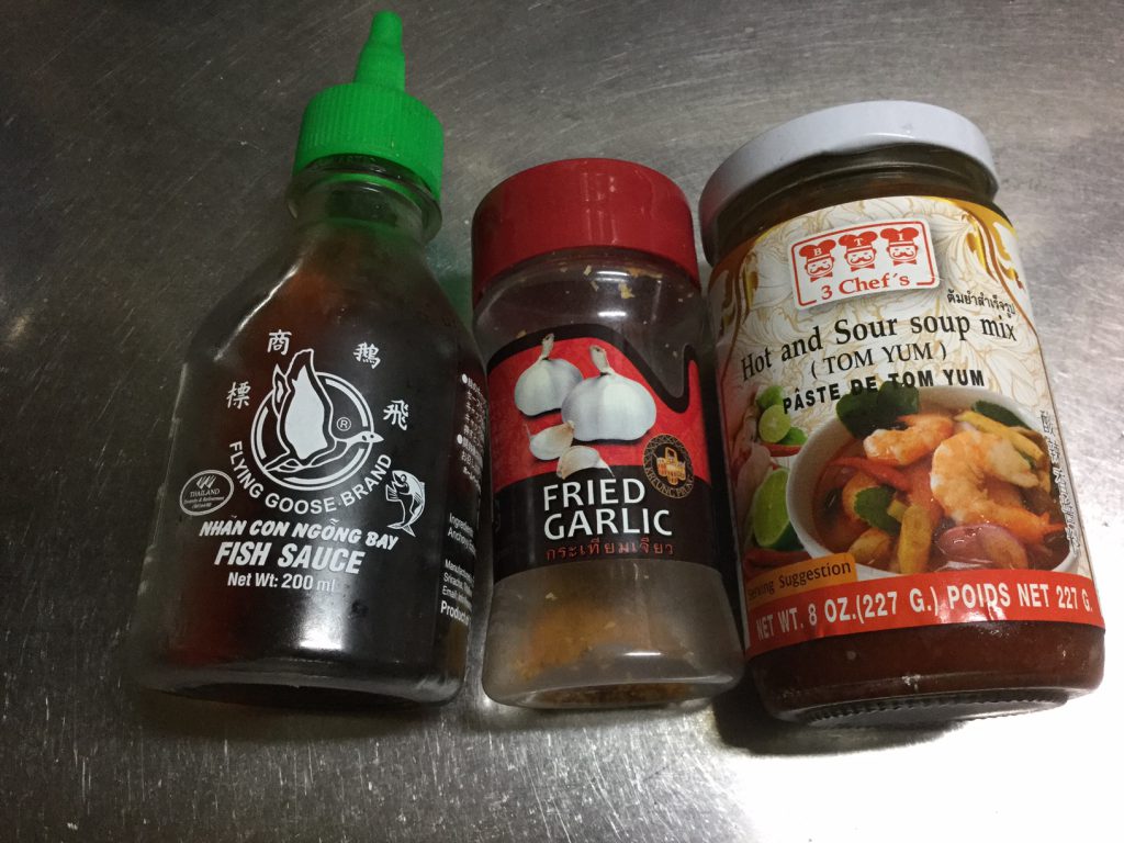 Thai nampla fish sauce, fried garlic, and tom yum paste for tom yum cup noodles fried rice