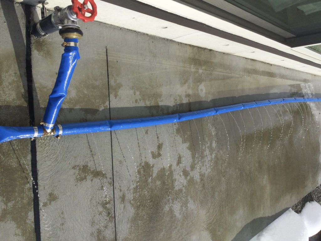 Blue snow removal hose set up around a building in Minamiuonuma, Niigata, Japan